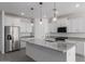 Bright kitchen features white cabinets, stainless steel appliances, and a large granite island with pendant lighting at 16004 W Honeysuckle Dr, Surprise, AZ 85387