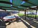 Outdoor kitchen area with bar, covered patio, and turf in a spacious backyard at 16210 W Durango St, Goodyear, AZ 85338