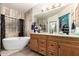 A modern bathroom features a large tub, double sink vanity, and stylish decorative touches at 16210 W Durango St, Goodyear, AZ 85338