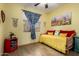 Bright bedroom with unique decor, sunny yellow walls, and hardwood floors at 16210 W Durango St, Goodyear, AZ 85338