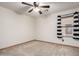 Neutral carpeted bedroom with ceiling fan and window with striped curtains at 16210 W Durango St, Goodyear, AZ 85338