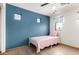Bedroom featuring a blue accent wall, light wood floors, small decor windows, and pink details at 16210 W Durango St, Goodyear, AZ 85338