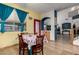 Dining area with floral table setting, bright yellow walls, uniquely decorated door, and archway to another room at 16210 W Durango St, Goodyear, AZ 85338