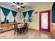 Cozy dining area features a floral table setting, bright yellow walls, and unique burgundy door at 16210 W Durango St, Goodyear, AZ 85338