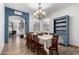 Dining room with a chandelier over a table for eight, a blue accent wall, and a vintage blue hutch at 16210 W Durango St, Goodyear, AZ 85338