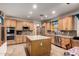 Charming kitchen featuring a center island, modern stainless steel appliances, and wood cabinets at 16210 W Durango St, Goodyear, AZ 85338