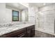 Bathroom features a double sink vanity with granite counters and glass enclosed shower at 17345 W Spur Dr, Surprise, AZ 85387