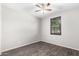 This bedroom has wood floors, a ceiling fan and a window with wood shutters at 17345 W Spur Dr, Surprise, AZ 85387