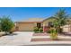 Charming single-story home featuring a two-car garage, desert landscaping, and neutral color palette at 17345 W Spur Dr, Surprise, AZ 85387