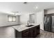 Well-designed kitchen featuring a large island, stainless steel appliances, and dark wood cabinets at 17345 W Spur Dr, Surprise, AZ 85387