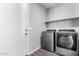 Laundry room with washer, dryer, and built-in shelf at 17345 W Spur Dr, Surprise, AZ 85387