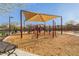Community playground area covered in woodchips with canopy covers at 17345 W Spur Dr, Surprise, AZ 85387