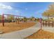 Community playground with swings, climbing structure, and pathway at 17345 W Spur Dr, Surprise, AZ 85387