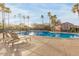 Community pool and lounge area with palm trees and blue skies at 17345 W Spur Dr, Surprise, AZ 85387