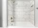 Updated bathroom shower with marble look tile, modern fixtures and built-in shelf at 17345 W Spur Dr, Surprise, AZ 85387