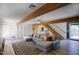 Bright living room with exposed beams, hardwood floors, and access to outdoor patio at 1750 E Mallory St, Mesa, AZ 85203