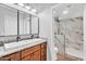 Bathroom featuring double sinks, granite countertops, wooden cabinets, and a glass-enclosed shower at 1825 W Ray Rd # 1119, Chandler, AZ 85224