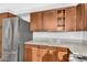 Close-up of kitchen featuring stainless steel refrigerator and wooden cabinets with matching granite countertops at 1825 W Ray Rd # 1119, Chandler, AZ 85224
