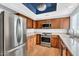 Modern kitchen features stainless steel appliances, granite countertops, and wooden cabinets with matching wood floors at 1825 W Ray Rd # 1119, Chandler, AZ 85224