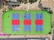 Aerial view featuring well-maintained pickleball courts, with blue and red court colors, surrounded by lush greenery at 1825 W Ray Rd # 1119, Chandler, AZ 85224