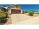 A tan one-story home featuring a two-car garage and low-maintenance landscaping at 1950 E Kings Ave, Phoenix, AZ 85022