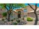 Home featuring desert landscaping, shade trees, arched windows and a front porch at 19506 N 73Rd Ave, Glendale, AZ 85308