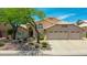Charming home featuring a three car garage, desert landscaping, and a beautiful shade tree at 19506 N 73Rd Ave, Glendale, AZ 85308
