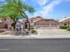 Beautiful home showcasing a three-car garage, and desert landscaping with mature trees at 19506 N 73Rd Ave, Glendale, AZ 85308