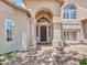 Inviting front entrance features an ornate security door, neutral stucco, manicured landscaping, and a charming walkway at 19506 N 73Rd Ave, Glendale, AZ 85308