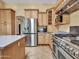 A modern kitchen with stainless steel appliances, wood cabinets, and granite countertops at 19506 N 73Rd Ave, Glendale, AZ 85308