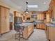 Bright kitchen with island, stainless appliances, tile floors, and ample wood cabinets under skylight at 19506 N 73Rd Ave, Glendale, AZ 85308