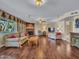 Open-concept living room with hardwood floors, a stone fireplace, and ample natural light at 19506 N 73Rd Ave, Glendale, AZ 85308