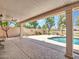 Covered patio offering a comfortable space to enjoy the pool and well-maintained backyard landscaping at 19506 N 73Rd Ave, Glendale, AZ 85308