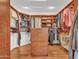Spacious walk-in closet with wood shelving and center island with granite counter at 19506 N 73Rd Ave, Glendale, AZ 85308