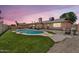 Backyard with a sparkling pool, a well-manicured lawn, and a covered patio perfect for outdoor relaxation at 2025 E Magdalena Dr, Tempe, AZ 85283