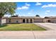 Charming single-story home featuring a manicured lawn and arched entryway under a bright blue sky at 2025 E Magdalena Dr, Tempe, AZ 85283