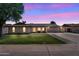 Charming single-story home with a manicured lawn and arched entryway at twilight at 2025 E Magdalena Dr, Tempe, AZ 85283