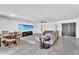 Open-concept living and dining area with gray wood floors, a large sectional couch, and a mounted TV at 2025 E Magdalena Dr, Tempe, AZ 85283