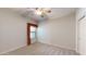 Carpeted bedroom featuring a ceiling fan, a window with curtains, and a closet at 21320 N 56Th St # 1158, Phoenix, AZ 85054