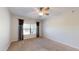 Comfortable bedroom with neutral carpet, a ceiling fan, and window with decorative curtains at 21320 N 56Th St # 1158, Phoenix, AZ 85054