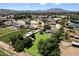 Scenic aerial view of a residential property with a large green space, complemented by mature trees and surrounding landscape at 23265 S Via Del Arroyo --, Queen Creek, AZ 85142
