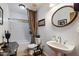 Cozy bathroom featuring subway tile shower, pedestal sink and decorative mirror at 23265 S Via Del Arroyo --, Queen Creek, AZ 85142