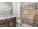 Bathroom with wood vanity, toilet, mirror, and shower with brown curtain at 25601 N 140Th Ln, Surprise, AZ 85387