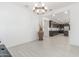 Open dining area showcasing a modern chandelier and views into the kitchen with dark cabinets and stainless steel appliances at 25601 N 140Th Ln, Surprise, AZ 85387