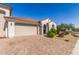 Inviting single-story home features a red-tiled roof, stucco exterior, and a well-manicured front yard with paver driveway at 25601 N 140Th Ln, Surprise, AZ 85387