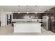 Modern kitchen featuring dark wood cabinets, stainless steel appliances, a white countertop island, and stylish pendant lighting at 25601 N 140Th Ln, Surprise, AZ 85387