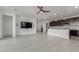 Bright living room with white tile flooring, seamlessly connecting to the kitchen with dark cabinets and white countertops at 25601 N 140Th Ln, Surprise, AZ 85387