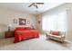 Bedroom features red bedding, side tables with lamps, carpet flooring, and a sitting couch at 2567 E San Isido Trl, Casa Grande, AZ 85194