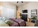 Bedroom features a ceiling fan, TV, large closet, and a bed with a patterned quilt, creating a cozy retreat at 2567 E San Isido Trl, Casa Grande, AZ 85194