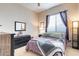 Bedroom featuring a dark wood dresser, a large window with curtains, and a plush bed with a patterned quilt at 2567 E San Isido Trl, Casa Grande, AZ 85194
